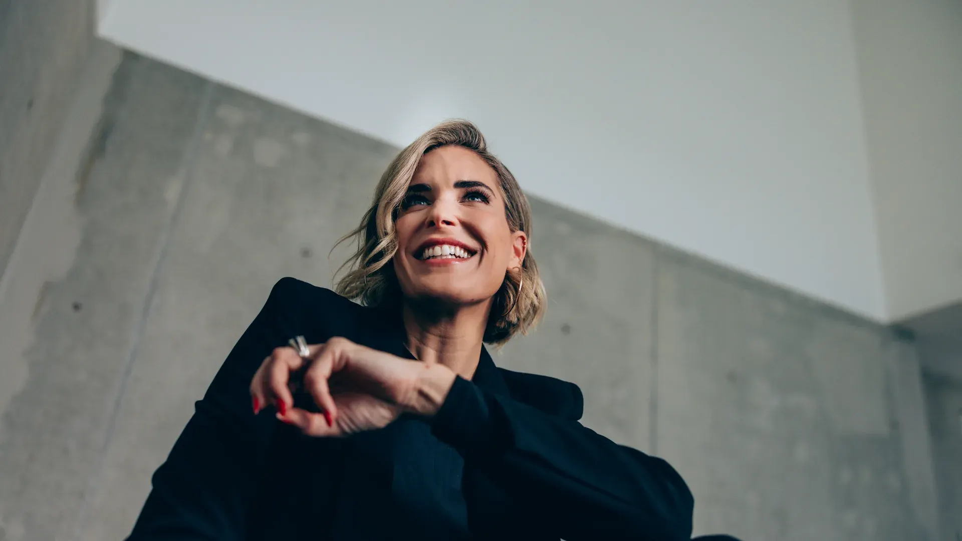 Elke Rock im schwarzen Blazer, lachend, von unten fotografiert