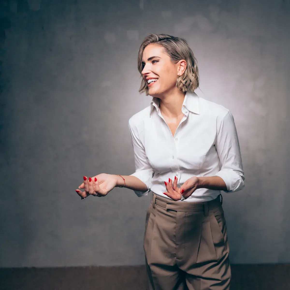 Elke Rock gestikuliert lachend in weißer Bluse